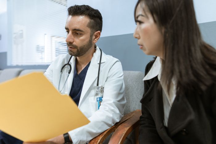 Doctor discusses health records with a patient in a clinical setting