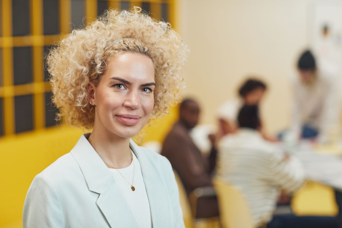 Woman in light blue blazer smiling