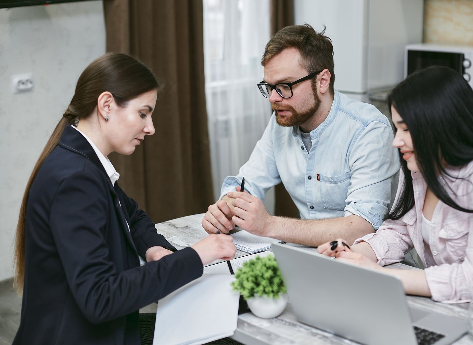 A couple discusses financial documents with their advisor