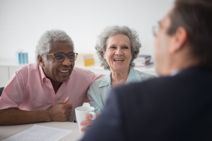 An elderly couple in conversation with a professional advisor