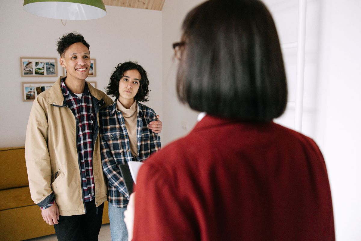Young couple discussing real estate options with an agent indoors